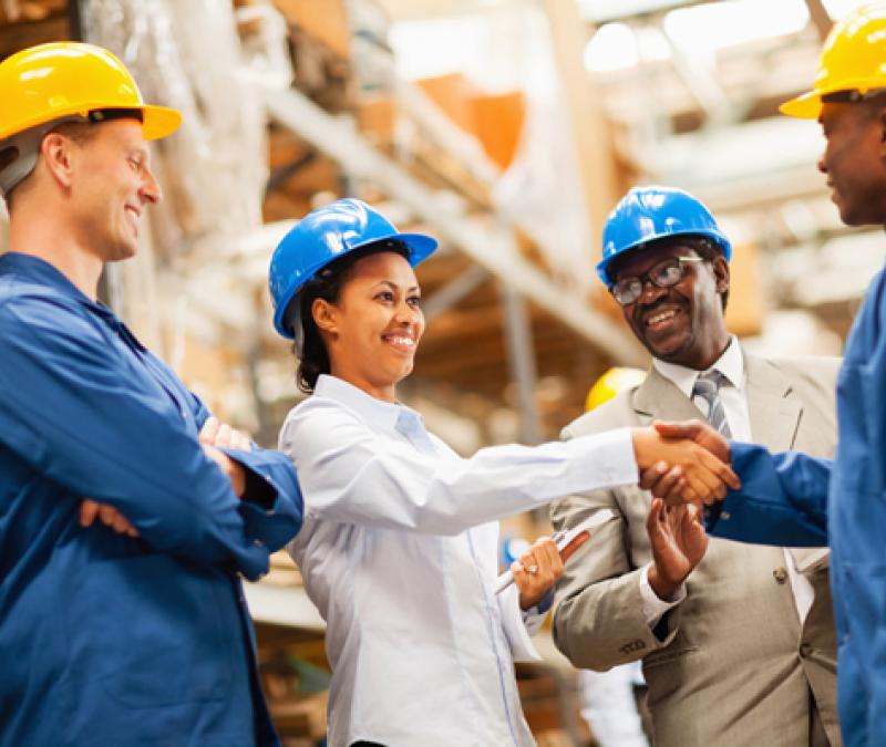 Warehouse manager shaking hands with warehouse worker